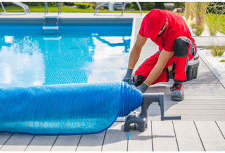 Image of a pool tech preparing a pool closing by rolling out the pool cover