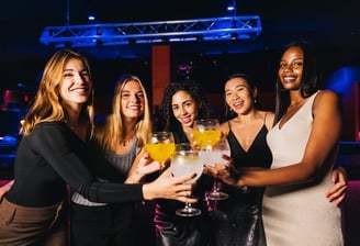 Group of women toasting with cocktails during a hosted nightlife crawl in Downtown Las Vegas.