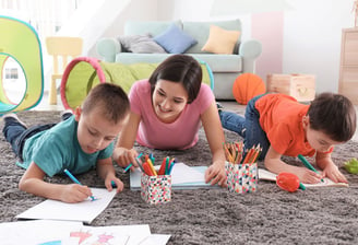 girl with two children colouring