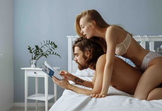 a couple in bed reading about UroFill the superior penis enlargement procedure internationally