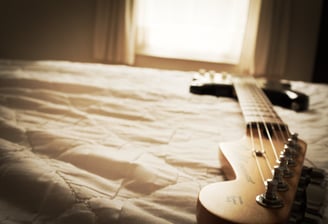 Electric guitar on bed