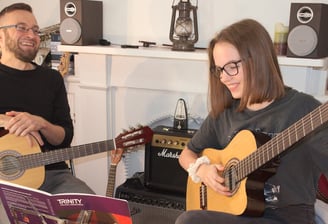 A guitar lesson with a young adult student