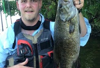 a man holding a fish on a boat