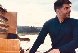 a man sitting on a bench in front of a piano