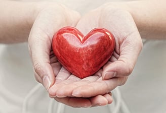 a person holding a red heart shaped object