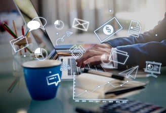 uma pessoa sentada em uma mesa com um laptop e uma xícara de café