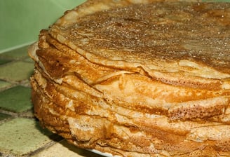 a stack of pancakes with cinnamon syrup on a plate