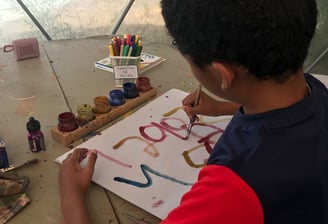 boy painting numbers on paper