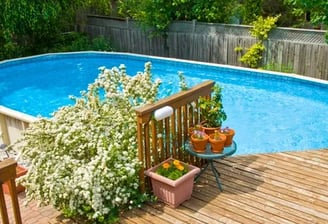 an above ground pool with a custom built deck with stairs