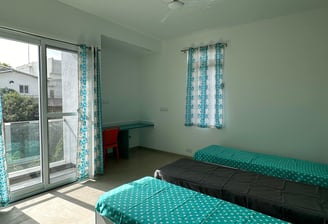 Spacious twin-sharing PG room in Banglore with a balcony, modern furniture, A/C and luxury.