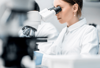 Scientist examining samples under a microscope in the research laboratory