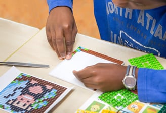 Human creating a picture with hands using transparent baseplate and colorful pixel squares
