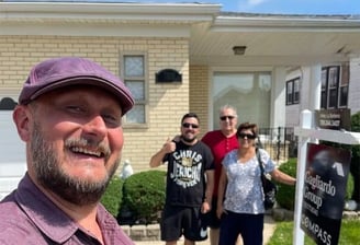 Andy Albright stading in front of a house with happy real estate clients
