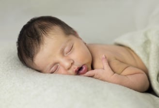Sessió de fotos newborn a Girona amb una bebè recent nascuda dormint en estudi fotogràfic