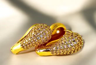a pair of gold shoes with a gold shoelaced shoe