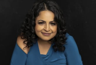 A woman sitting with crossed arms and a smile