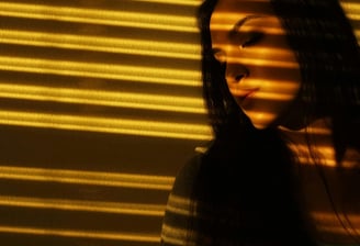 A woman standing near automated window blinds
