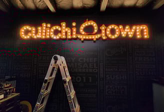 A ladder up to a sign that says culichi town
