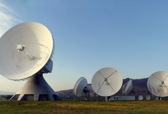 a group of satellite sitting in a field