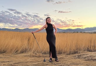 a woman in a black dress standing in a field