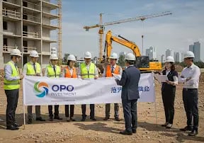 a group of people standing around a banner board, opo investment ; "investment opportunities 2025,