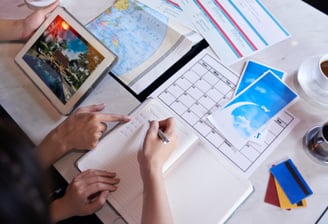 Close-up shot of unrecognizable couple taking necessary notes and planning luxury cruise vacation w