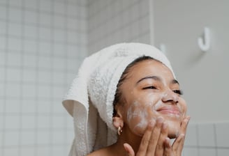a woman in a towel doing her skin care on her face