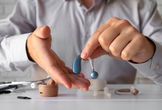 a man holding a pair of ear buds in his hands