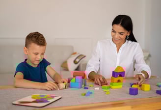 a woman and a boy playing with blocks