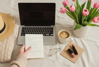 a person holding a notebook in front of a laptop computer