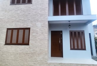 a house with a white brick wall and a brown door