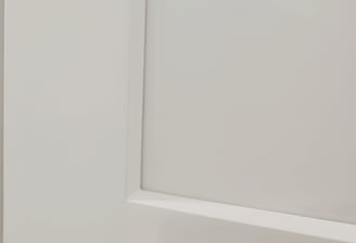 Close-up of a white shaker cabinet door showing smooth painted finish and clean recessed panel — hig