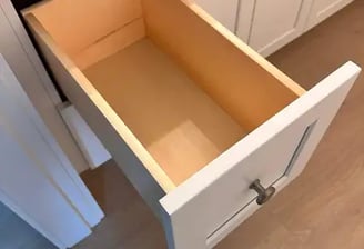 Open  box  inside a white shaker cabinet, showing solid wood construction and smooth finish.
