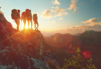 Hikers-standing-on-mountain-summit-at-sunset