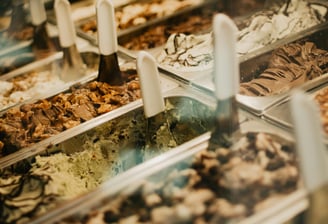 a variety of ice creams in an ice cream shop window.