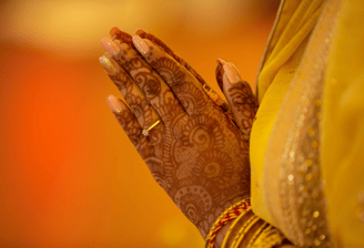 hindu woman praying with folded hands, has mehendi on hands