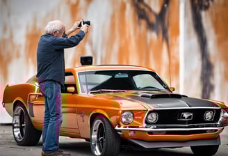a man taking a picture of himself in a rear view mirror