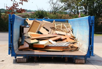 Sperrmüll, hauptsächlich Holz, in einem großen blauen Container