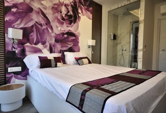 a bed with a large floral wallpapered wall