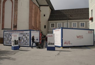 Besucher erkunden die Außenanlage der mobilen Ausstellung "Aus weg los!".