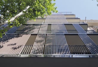 Fachada moderna con lamas verticales de madera y estructura metálica para protección solar y estética arquitectónica