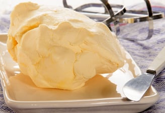 Homemade butter on a tray with a knife