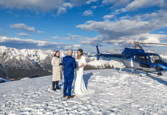 Couple getting married on top of a mountain in Banff with a helicopter in the background