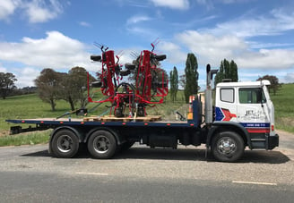 transporting new hay rake to farmer from dealer shop