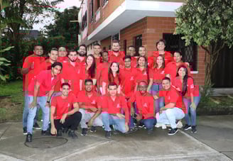 a group of people in red shirts and jeans posing for a group photo