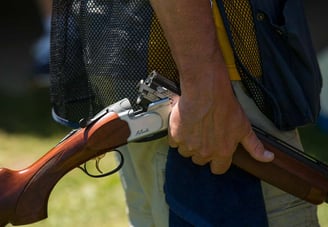 man holding an over under shotgun