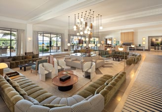 Grand salon at Villa La Gratitud with designer sofas, statement chandelier, and garden views through