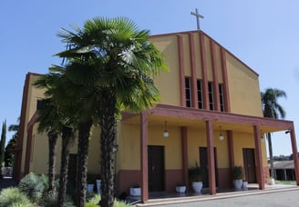 a church with a cross on the side of the road