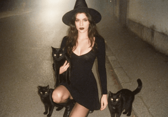 Une sorcière entourée des ses chats noirs pour la journée internationale du chat noir.