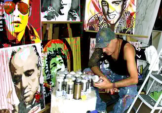 Sérgio Astral, em seu ateliê, com quadros em pop-art.